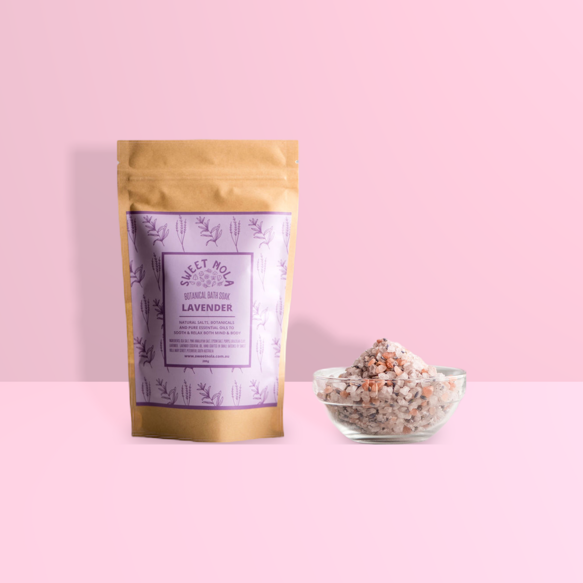 Lavender Bath soak in paper stand up pouch with purple label. On the right is a small glass bowl filled with the bath soak salts.