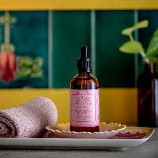 Ylang Ylang and palmarosa bath and body oil. In a 100ml glass amber dropper bottle with pink label.